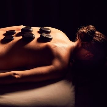 Woman receiving a back massage with hot stones