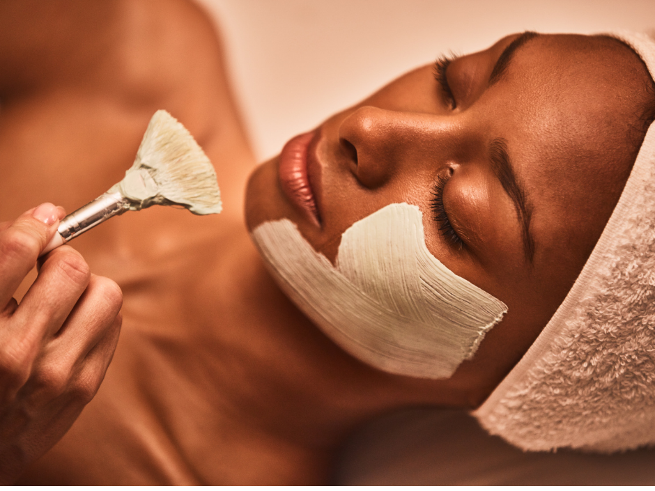 Woman receiving a soothing SkinCeuticals face mask from an esthetician.