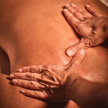 Viva Day Spa massage therapist working on upper back muscles of a female client during a Swedish massage.