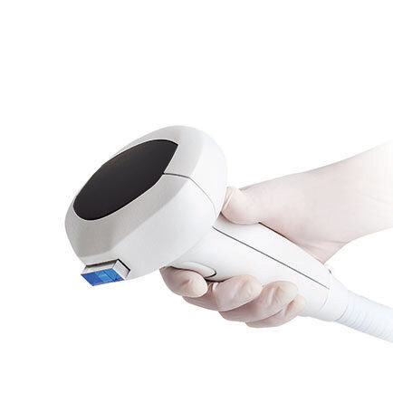 Gloved hand holding the Lumecca IPL Photofacial hand held applicator.