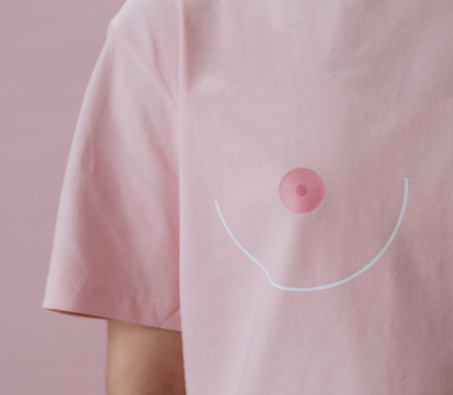 Woman wearing a pink t-shirt with a drawing of a nipple and breast to highlight the importance of getting a mammogram.