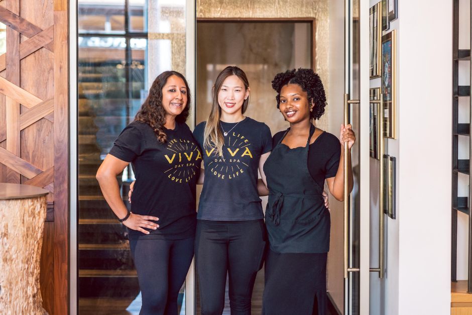 Three female massage therapists standing in the interior doorway at Viva Day Spa + Med Spa in Austin, TX.