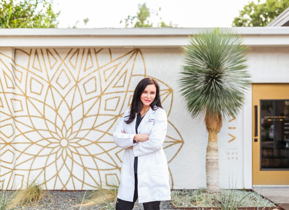 Julia Hoy is an aesthetic injector at Viva Day Spa + Med Spa in Austin, TX. She's standing in front of the 35th Street med spa location.