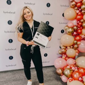 Jamie Villareal, who is a medical esthetician at Viva Day Spa + Med Spa in Austin, TX holding her Master Hydrafacialist certificate that she earned from Hydrafacial.