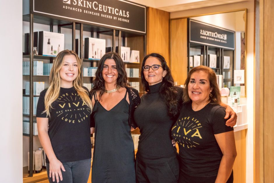 Four of Viva Day Spa + Med Spa's estheticians standing in a group in front of the SkinCeuticals product display in Viva Domain Northside's retail area in north Austin.